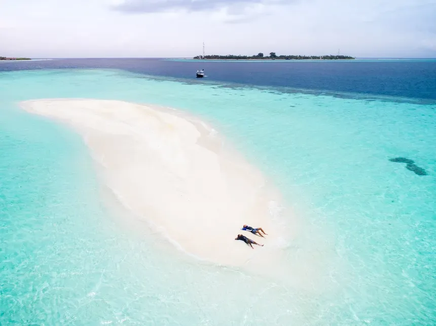 Vue aérienne d'une plage de sable blanc avec des personnes se relaxant