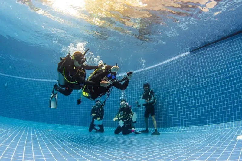 Plongeurs en formation dans une piscine, instructeur donnant des consignes