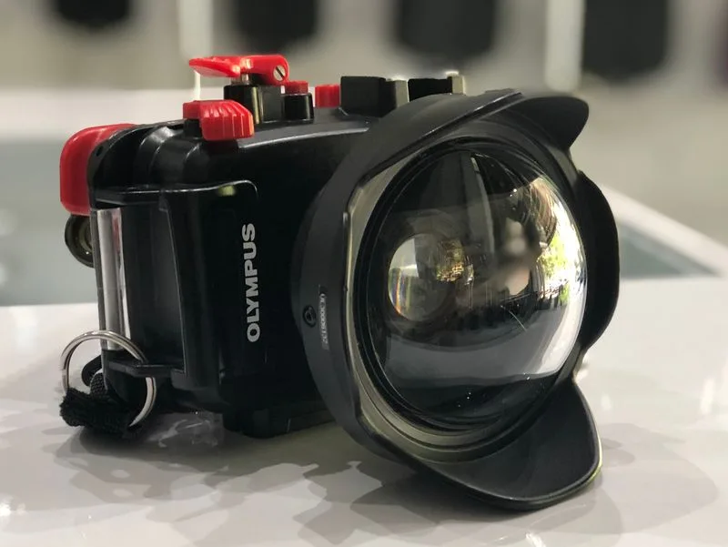 Appareil photo étanche Olympus avec caisson et flash rouge sur surface