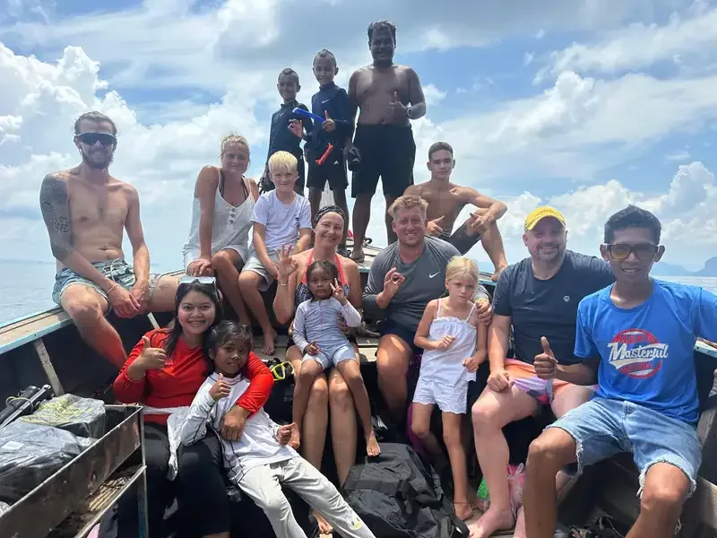 Groupe de personnes souriantes à bord d'un bateau en mer