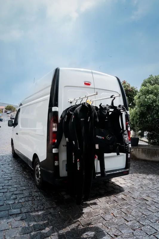 Fourgon de transport avec combinaisons et équipements de plongée accrochés
