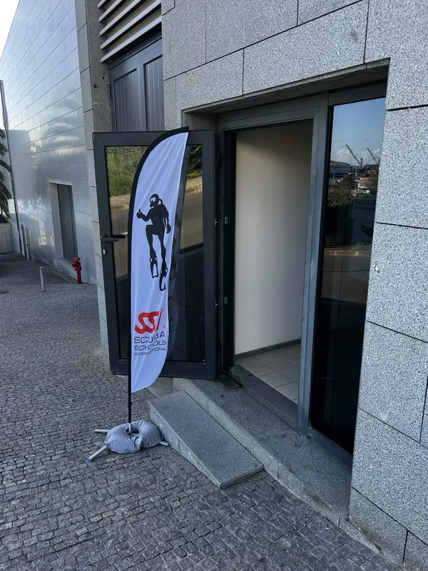 Entree d'un centre de plongee avec un drapeau publicitaire rouge