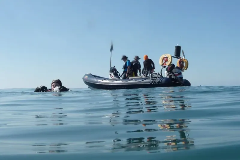 Plongeurs et bateau semi-rigide sur une mer calme et ensoleillée
