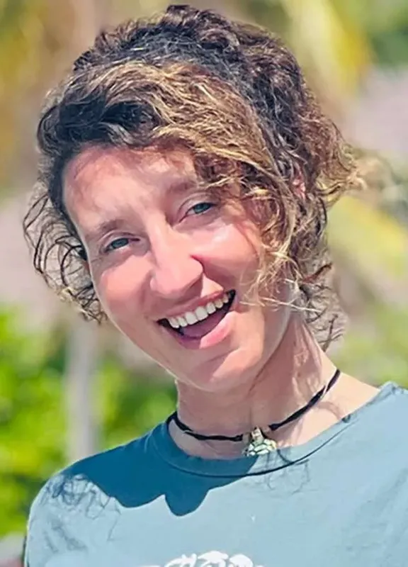 Portrait souriant d'une femme aux cheveux bouclés en extérieur