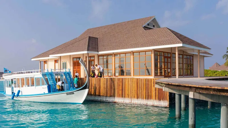 Bateau de plongée amarré devant un bâtiment avec des personnes