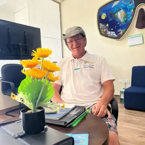 Un homme souriant assis à un bureau dans un intérieur clair
