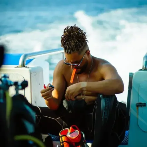 Plongeur torse nu manipule un appareil sur un bateau en mer