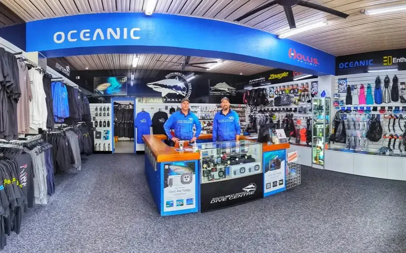 Intérieur d'un centre de plongée avec deux employés derrière un comptoir