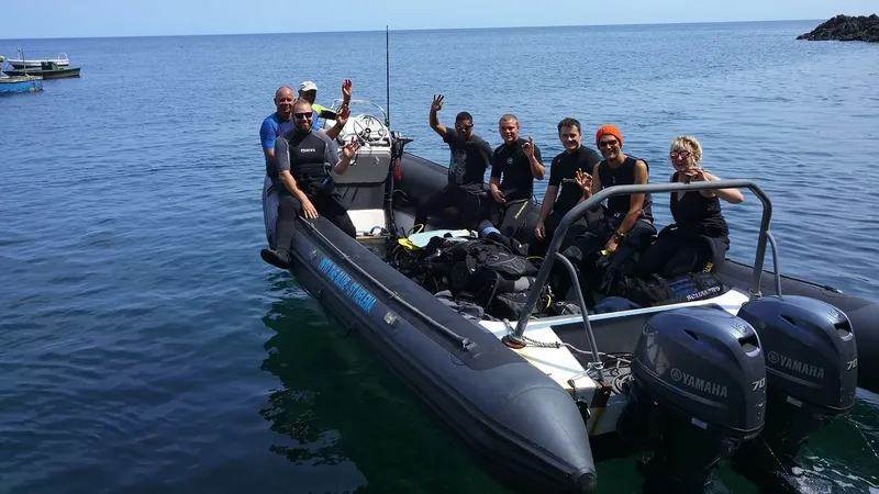 Groupe de plongeurs souriants à bord d'un bateau semi-rigide en mer