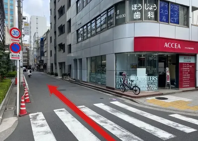 Rue urbaine avec passage piéton, bâtiments et personnes marchant