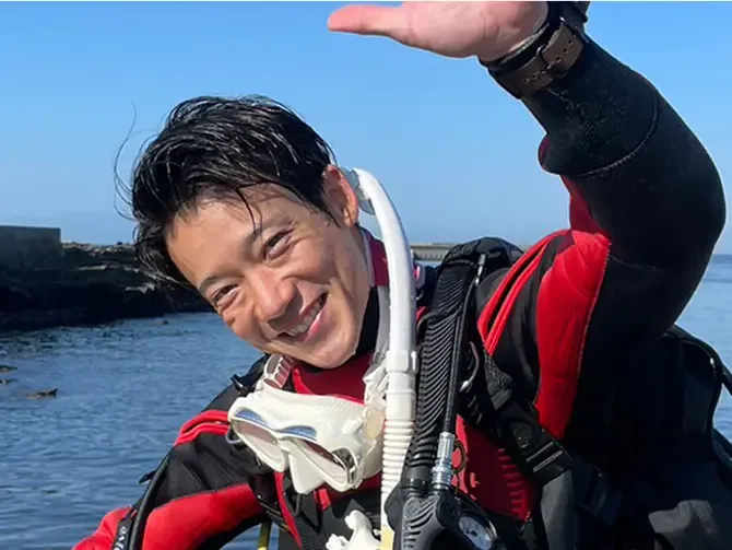 Plongeur souriant avec masque et détendeur, prêt pour une immersion