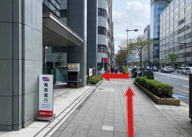 Façade d'immeuble avec enseigne japonaise et flèches rouges directionnelles
