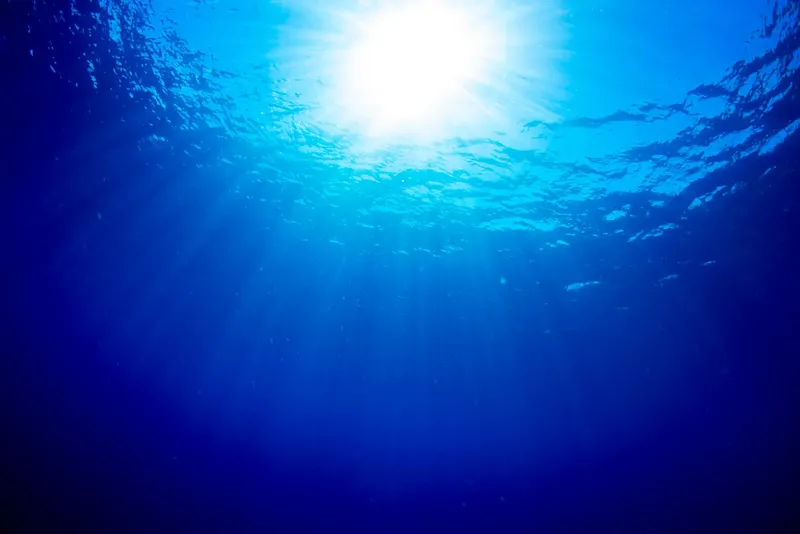 Rayons de soleil perçant la surface de l'eau en plongée