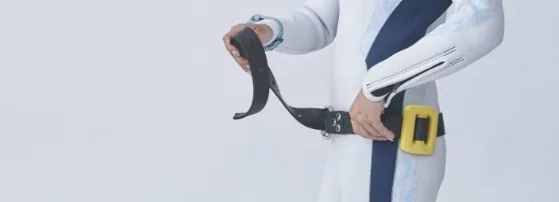 Plongeur ajustant sa ceinture et son gilet stabilisateur blanc