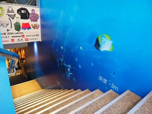 Décor mural avec des poissons et des plongeurs, escalier en premier plan