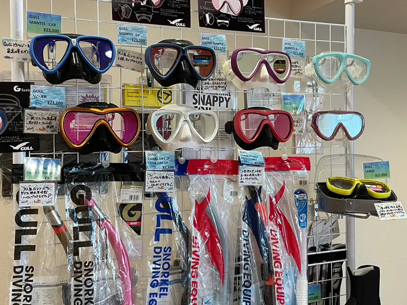 Rayonnage de masques et tubas de plongée de différentes couleurs et marques