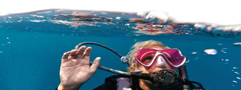 Plongeur avec masque et détendeur, vue à moitié immergée