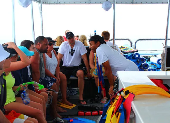 Groupe de plongeurs assis sur un bateau, préparation de la sortie