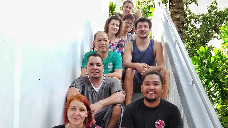 Groupe de personnes souriantes posant sur un escalier métallique blanc