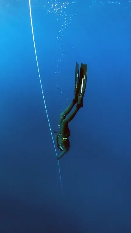 Apnée : une plongeuse descend le long d'un câble vertical