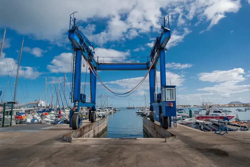 Port de plaisance avec une grue de levage pour bateaux et ciel bleu