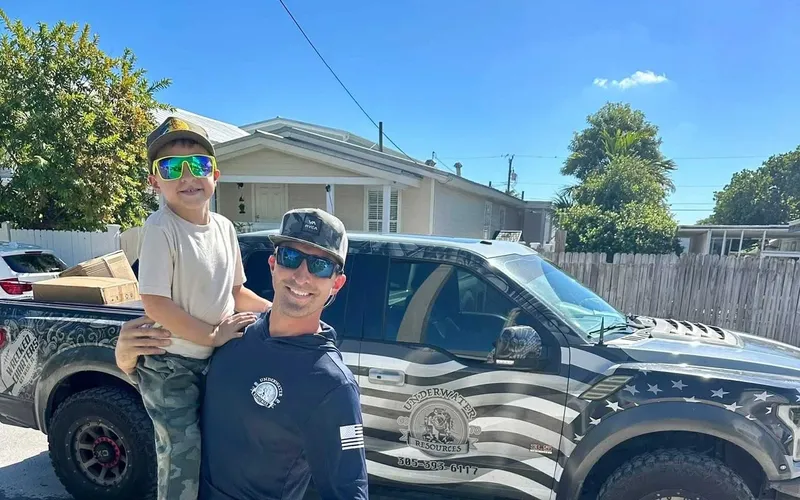 Deux personnes souriantes posent devant un pick-up décoré