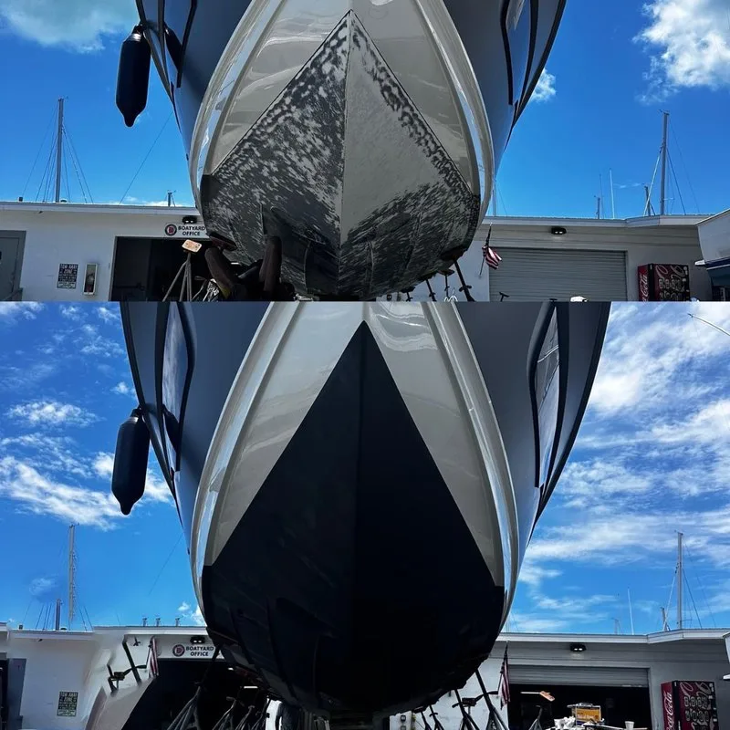 Bateau de plongée blanc et noir sur remorque devant un bâtiment