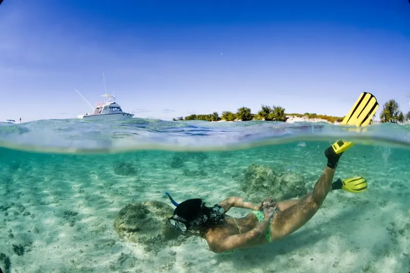 Femme pratiquant le snorkeling dans une eau turquoise et claire
