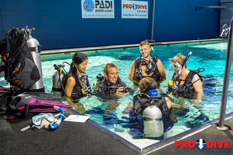 Cours de plongée en piscine avec plusieurs participants équipés