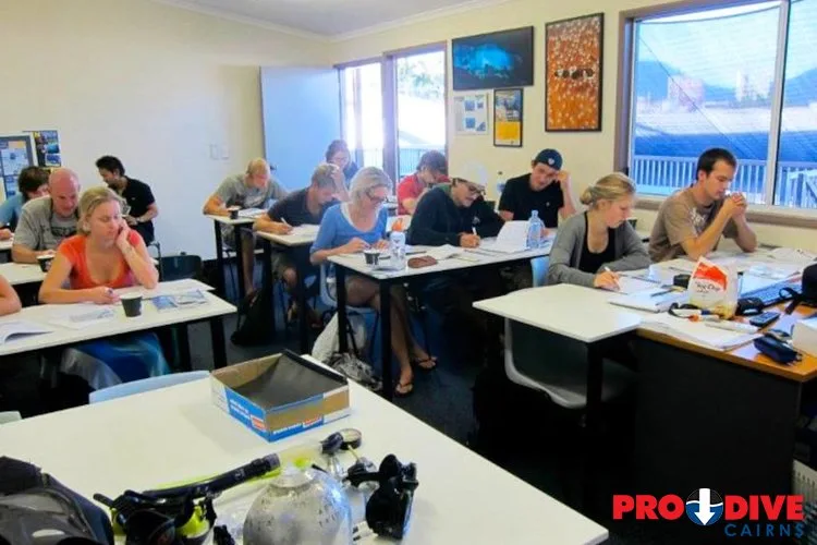 Cours de plongée en salle avec des participants prenant des notes