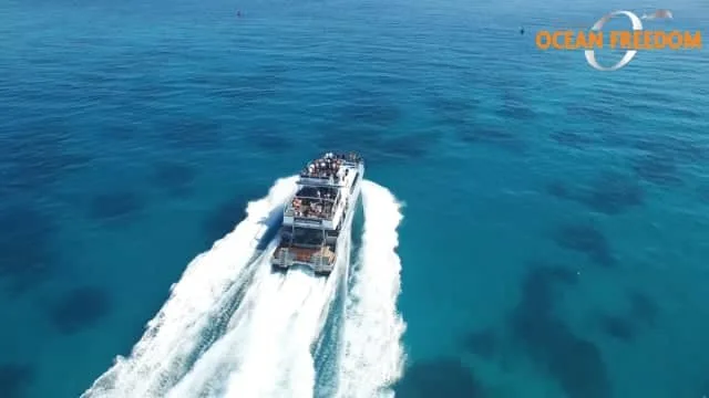 Bateau de plongée naviguant sur une mer turquoise avec des passagers
