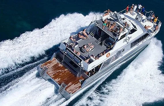 Grand bateau de plaisance en mer avec des passagers bronzant au soleil