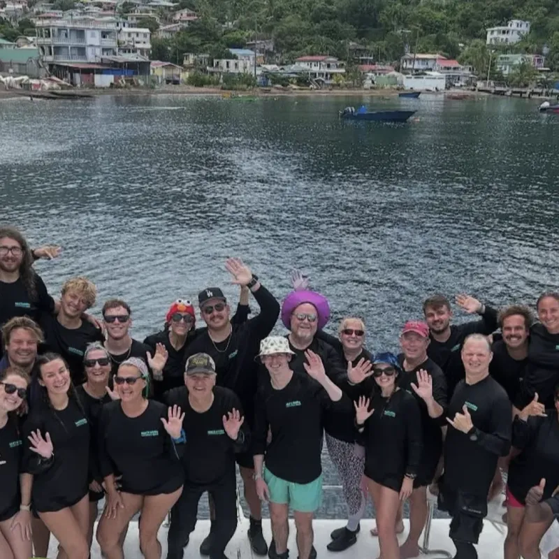 Groupe de personnes souriantes et saluant sur un bateau en mer