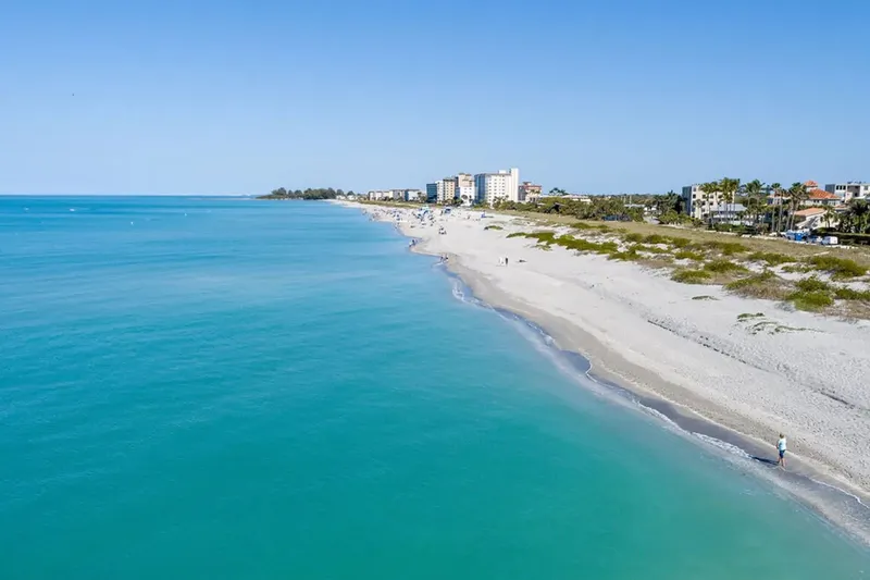 Vue aérienne d'une plage de sable fin avec une mer turquoise