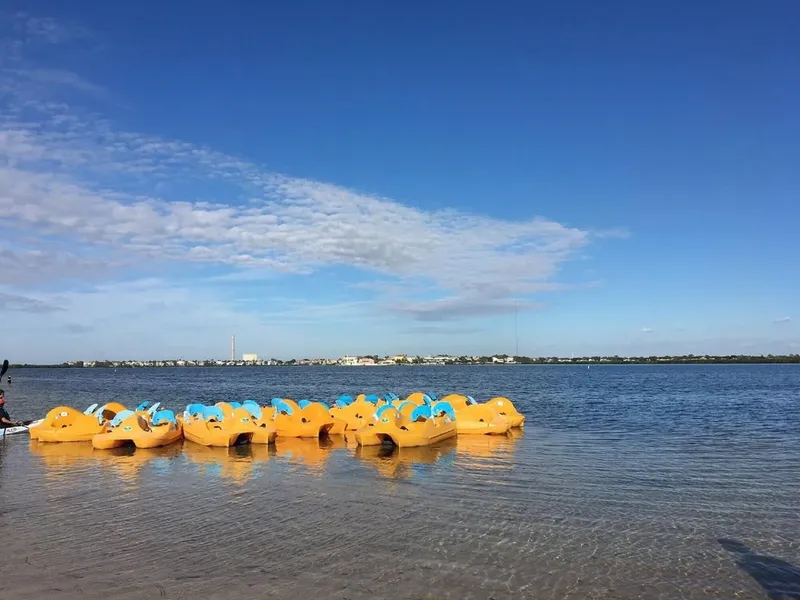 Rangée de kayaks jaunes et bleus sur une plage ensoleillée