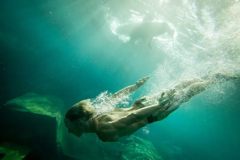 Nageur sous-marin, lumière du soleil filtrant à travers la surface de l'eau