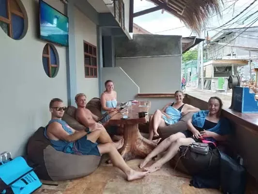 Groupe de personnes assises et détendues dans un espace extérieur ombragé