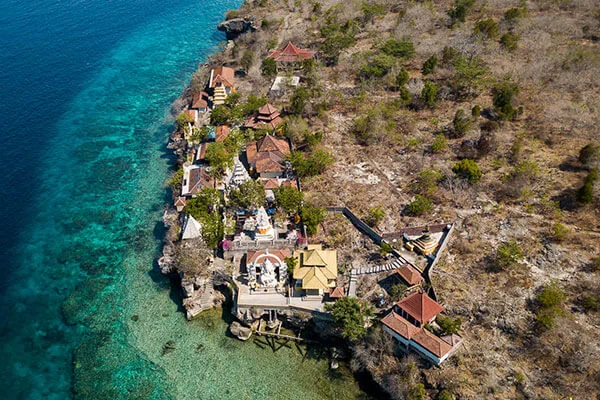 Vue aérienne d'un complexe de bâtiments près d'une côte rocheuse turquoise