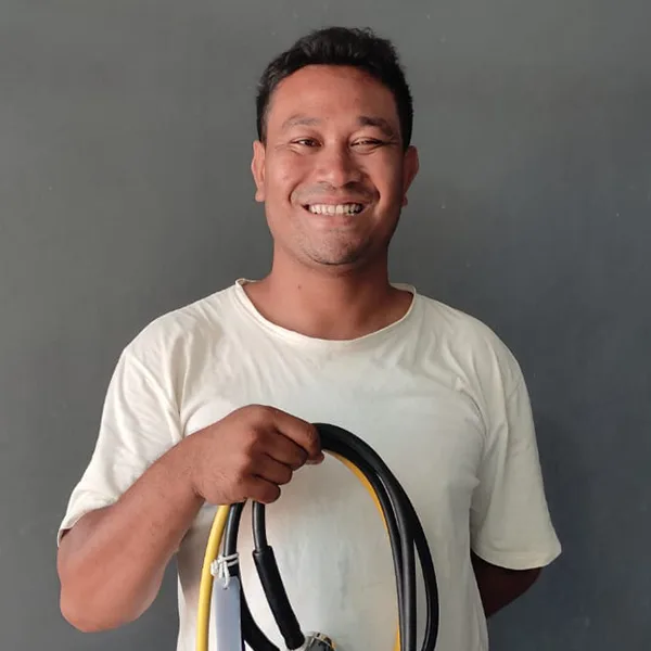 Un homme souriant tient un détendeur et un tuyau noir