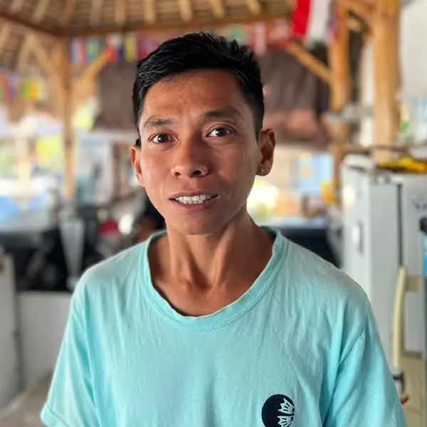 Portrait d'un homme souriant, regardant la caméra, en extérieur