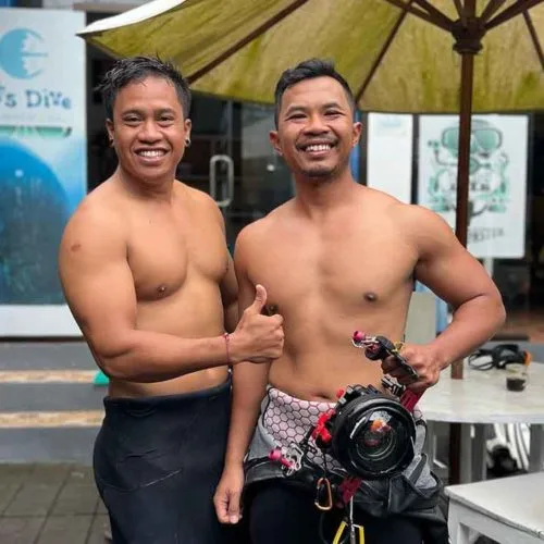 Deux hommes souriants torse nu avec équipement de plongée