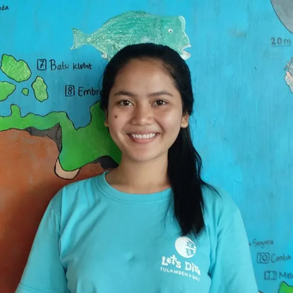 Portrait souriant d'une jeune femme devant une fresque marine colorée