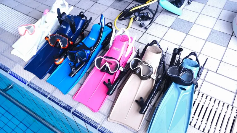 Palmes, masques et tubas de plongée alignés près d'une piscine