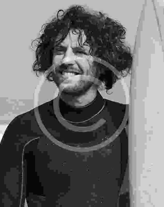 Portrait en noir et blanc d'un homme souriant avec cheveux bouclés