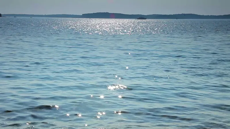 Vue d'une mer calme avec des reflets de soleil scintillants