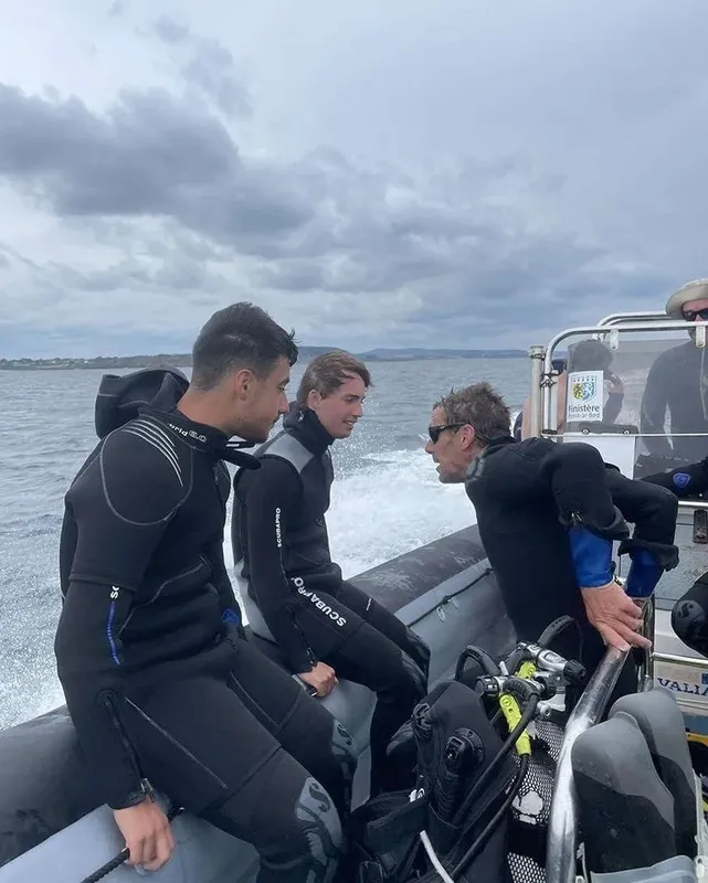 Plongeurs en combinaison sur un bateau semi-rigide, direction la mer