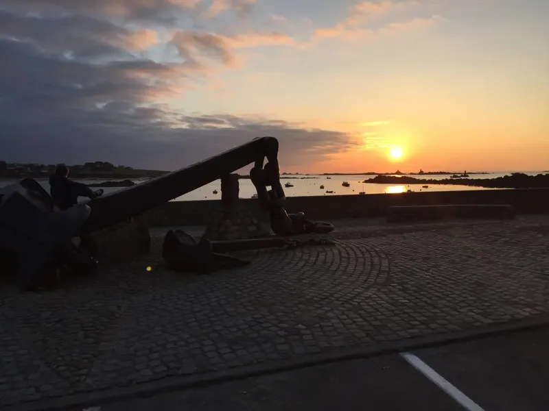Coucher de soleil sur un port avec des bateaux et une personne