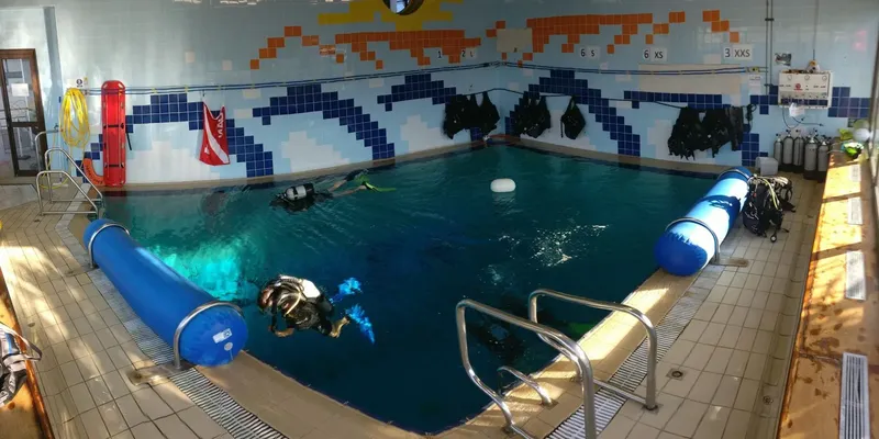 Plongée en piscine avec trois personnes équipées, formation débutants