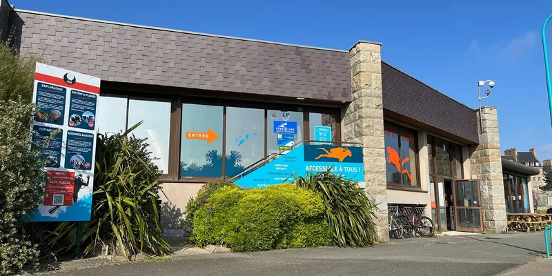 Façade d'un centre de plongée avec affiches et signalétique d'accès