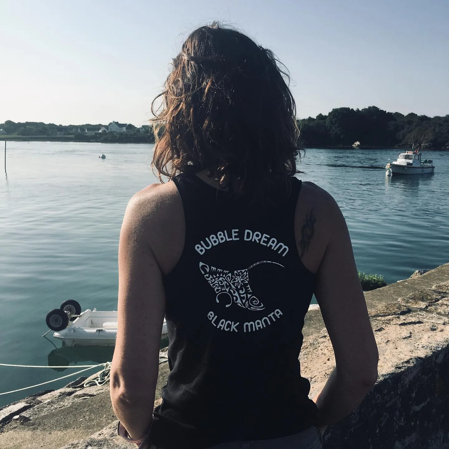 Femme regardant la mer, portant un débardeur avec un motif de raie manta